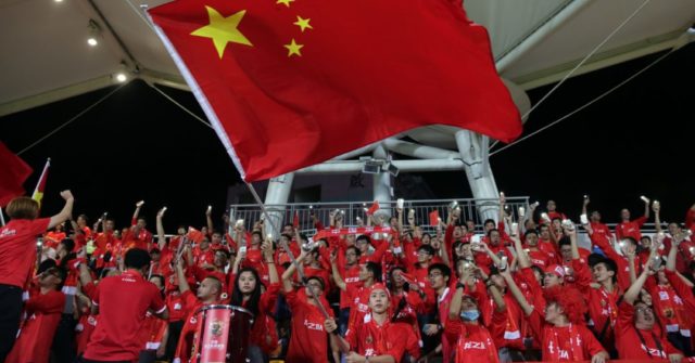 A Chinese fan waves the national flag during a world cup qualifier at Mong Kok stadium in Hong Kong on November 17, 2015. Hong Kong fans booed the anthem they share with China on Tuesday while some turned their backs and held up "boo" signs in a show of defiance before a crunch World Cup football qualifier with their mainland rivals.