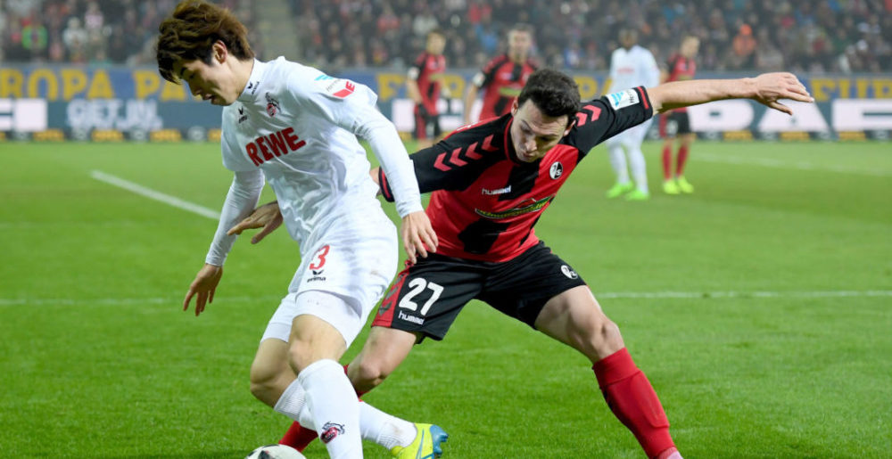 FREIBURG IM BREISGAU, GERMANY - FEBRUARY 12: Yuya Osaka of Koeln is challenged by Nicolas Hoefler of Freiburg during the Bundesliga match between SC Freiburg and 1. FC Koeln at Schwarzwald-Stadion on February 12, 2017 in Freiburg im Breisgau, Germany. (Photo by Matthias Hangst/Bongarts/Getty Images)