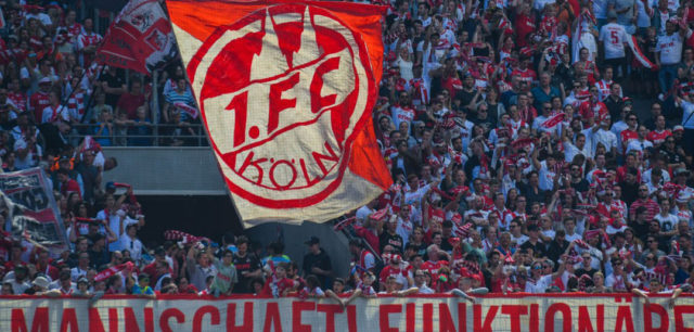 Cologne supporter wave flags during the German first division Bundesliga football match FC Cologne vs FC Bayern Munich in Cologne, western Germany, on May 5, 2018. (Photo by Patrik STOLLARZ / AFP) / RESTRICTIONS: DURING MATCH TIME: DFL RULES TO LIMIT THE ONLINE USAGE TO 15 PICTURES PER MATCH AND FORBID IMAGE SEQUENCES TO SIMULATE VIDEO. == RESTRICTED TO EDITORIAL USE == FOR FURTHER QUERIES PLEASE CONTACT DFL DIRECTLY AT + 49 69 650050 (Photo credit should read PATRIK STOLLARZ/AFP/Getty Images)