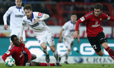 KARLSRUHE, GERMANY - MARCH 07: Matthias Bader (C) of Karlsruhe is challenged by Makana Baku (L) and Daniel Hagele of Grossaspach during the 3. Liga match between Karlsruher SC and SG Sonnenhof Grossaspach at Wildparkstadion on March 7, 2018 in Karlsruhe, Germany. (Photo by Alex Grimm/Bongarts/Getty Images)