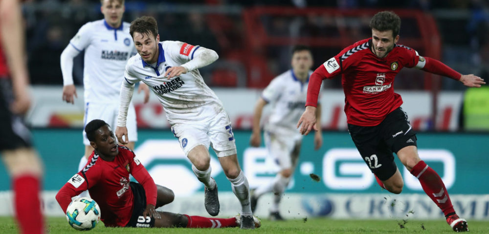 KARLSRUHE, GERMANY - MARCH 07: Matthias Bader (C) of Karlsruhe is challenged by Makana Baku (L) and Daniel Hagele of Grossaspach during the 3. Liga match between Karlsruher SC and SG Sonnenhof Grossaspach at Wildparkstadion on March 7, 2018 in Karlsruhe, Germany. (Photo by Alex Grimm/Bongarts/Getty Images)