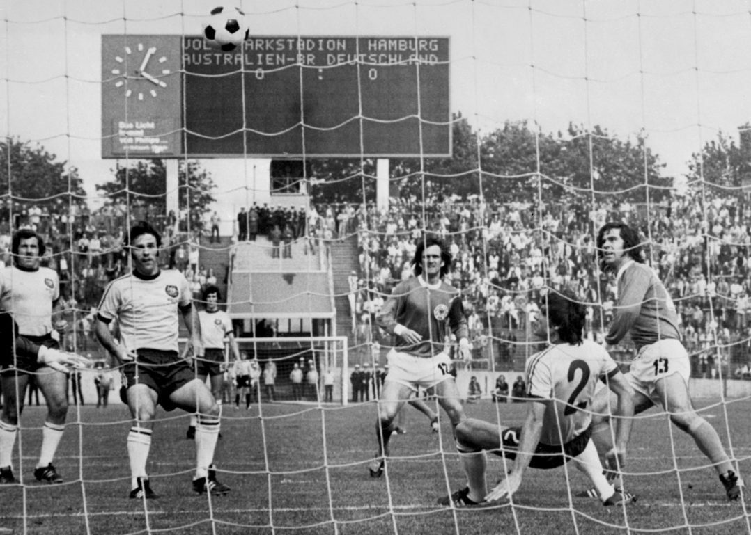 HAMBURG, GERMANY - JUNE 18: West German midfielder Wolfgang Overath (C) scores his team's first goal as teammate Gerd Mueller (R) and Australians (from L) Ray Richards, James Rooney and Doug Utjesenovic watch the ball go in the net during the World Cup first round soccer match between West Germany and Australia, 18 June 1974 in Hamburg. West Germany beat Australia 3-0. (Photo credit should read STAFF/AFP/Getty Images)