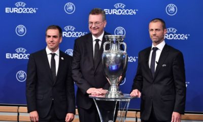 (FromL) Head of Germany's bid to host the Euro 2024 Philipp Lahm, German Football Association (DFB) president Reinhard Grindel and UEFA president Aleksander Ceferin pose with the UEFA Euro trophy after it was announced that Germany was elected to host the Euro 2024 fooball tournament during a ceremony at the headquarters of the European football's governing body in Nyon on September 27, 2018. - UEFA selected the host of the 2024 European Championship today in a vote pitting a safe German bid against a riskier Turkish proposal that offers a chance to explore new terrain. (Photo by Fabrice COFFRINI / AFP) (Photo credit should read FABRICE COFFRINI/AFP/Getty Images)