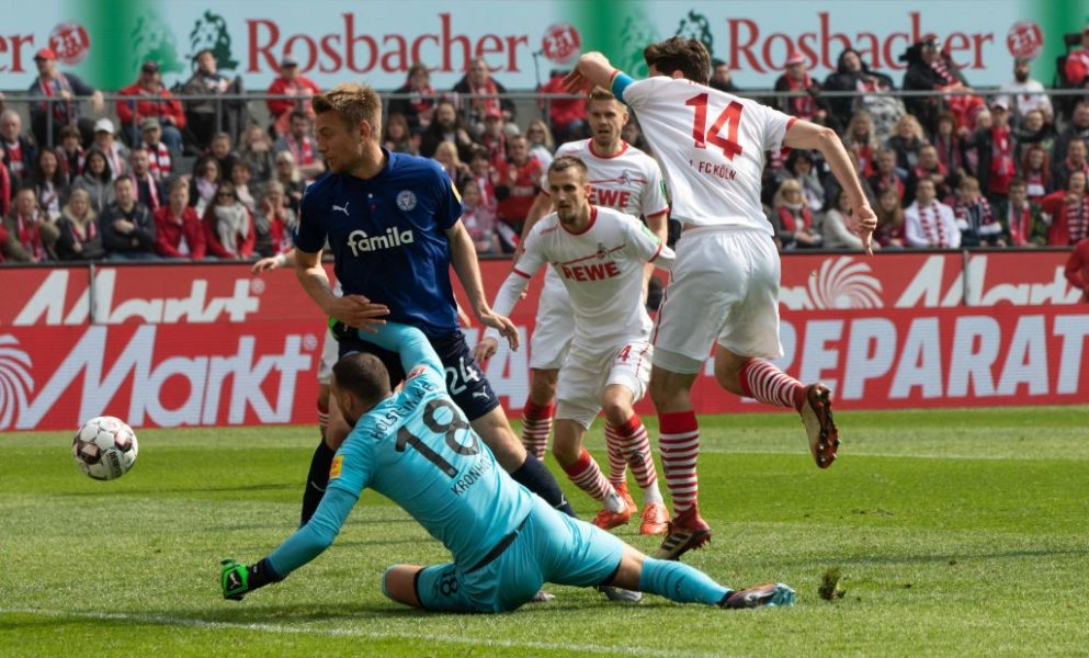 COLOGNE, GERMANY - MARCH 31: Jonas Hector of Cologne (R) and goalkeeper Kenneth Kronholm of Kiel battle for the ball during the Second Bundesliga match between 1. FC Koeln and Holstein Kiel at RheinEnergieStadion on March 31, 2019 in Cologne, Germany. (Photo by Juergen Schwarz/Bongarts/Getty Images)