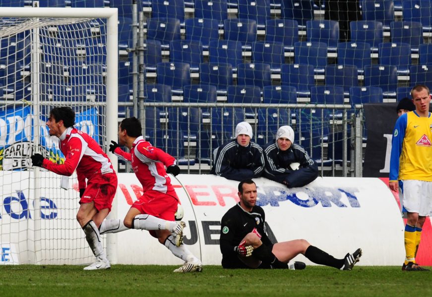 JENA, GERMANY - FEBRUARY 14 : Massimo Cannizzaro of FC Rot-Weiss Erfurt celebrates with his team mates his 0:1 goal while goalkeeper Carsten Nulle of FC Carl Zeiss Jena looks frustrated during the third league match between Carl Zeiss Jena and Rot-Weiss Erfurt at the Ernst-Abbe-Sportfeld Stadium on February 14, 2009 in Jena, Germany (Photo by Enrico Radloff/Bongarts/Getty Images for DFB)