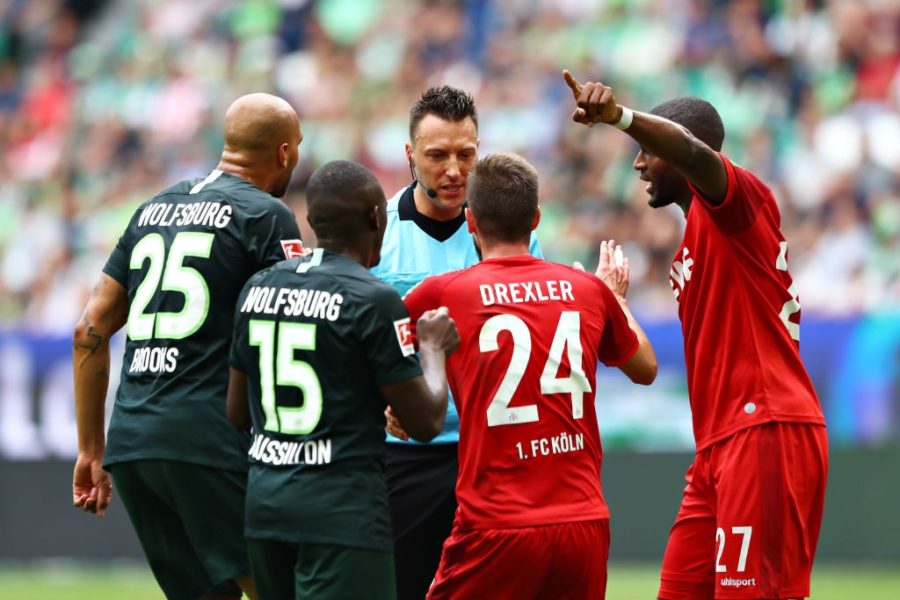 WOLFSBURG, GERMANY - AUGUST 17: Referee Sven Jablonski talks with players of VfL Wolfsburg and 1. FC Koeln during the Bundesliga match between VfL Wolfsburg and 1. FC Koeln at Volkswagen Arena on August 17, 2019 in Wolfsburg, Germany. (Photo by Martin Rose/Bongarts/Getty Images)