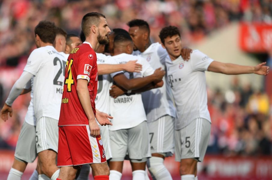 COLOGNE, GERMANY - FEBRUARY 16: Dominick Drexler of FC Koln cuts a dejected figure as Serge Gnabry of FC Bayern Muenchen celebrates after scoring his sides third goal during the Bundesliga match between 1. FC Koeln and FC Bayern Muenchen at RheinEnergieStadion on February 16, 2020 in Cologne, Germany. (Photo by Jörg Schüler/Bongarts/Getty Images)
