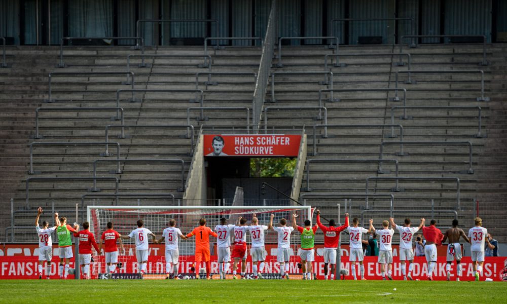 Cologne's players greet the absent fans in front of empty stands after the German first division Bundesliga football match FC Cologne v Eintracht Frankfurt on June 20, 2020 in Cologne, western Germany. (Photo by SASCHA SCHUERMANN / various sources / AFP) / DFL REGULATIONS PROHIBIT ANY USE OF PHOTOGRAPHS AS IMAGE SEQUENCES AND/OR QUASI-VIDEO (Photo by SASCHA SCHUERMANN/AFP via Getty Images)